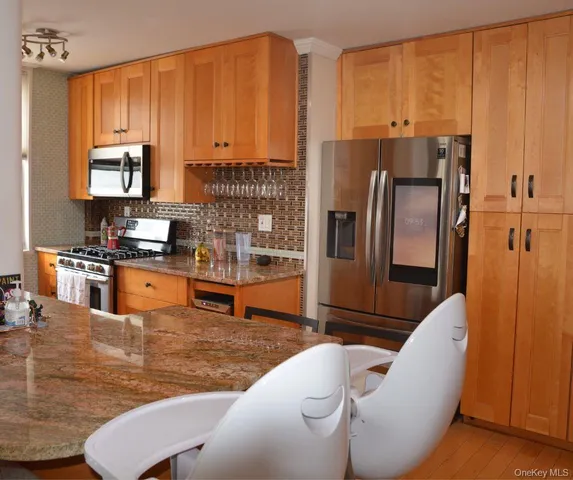 a kitchen with stainless steel appliances wooden cabinets a refrigerator and a stove top oven