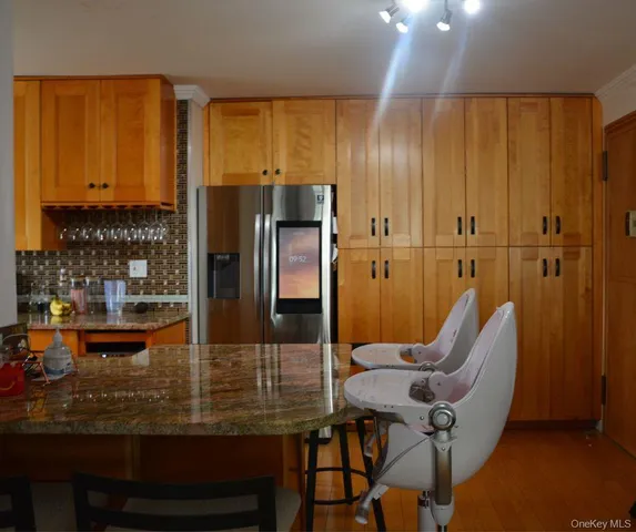 a kitchen with stainless steel appliances wooden floor dining table and chairs