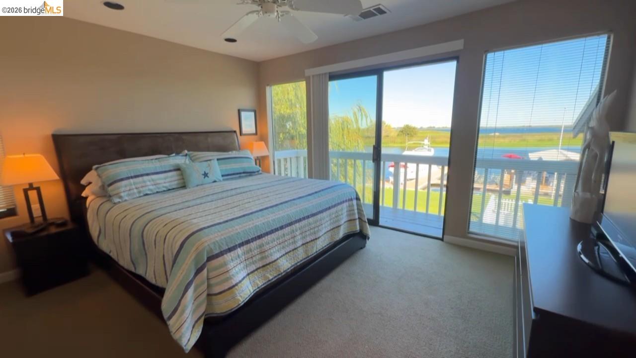 3777 Willow Road Bethel Island, CA 94511 - Photo 12 of 34 Bedroom with access to outside, dark colored carpet, and ceiling fan