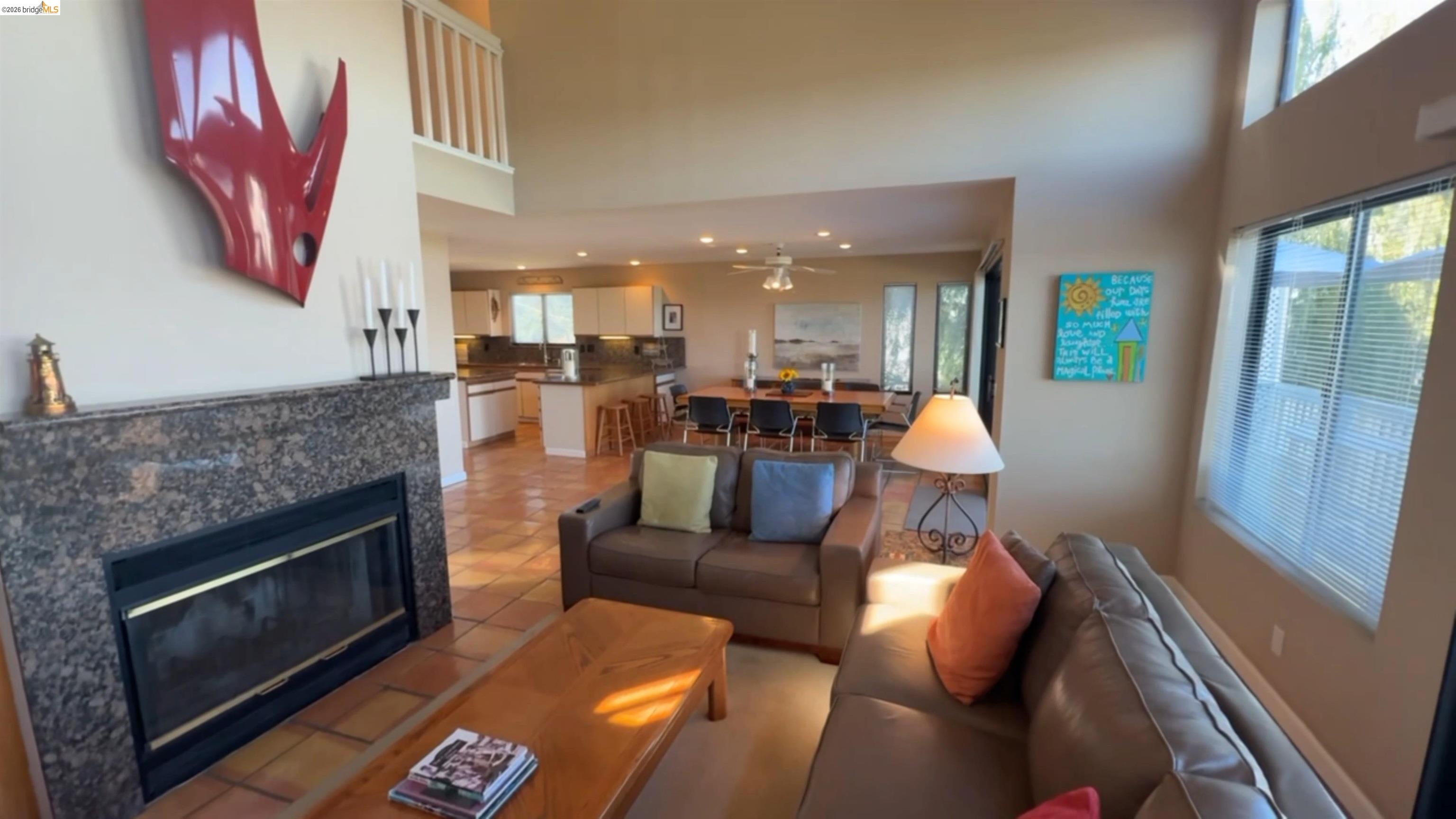 3777 Willow Road Bethel Island, CA 94511 - Photo 25 of 34 Living area featuring a tiled fireplace, ceiling fan, light tile patterned floors, and a high ceiling
