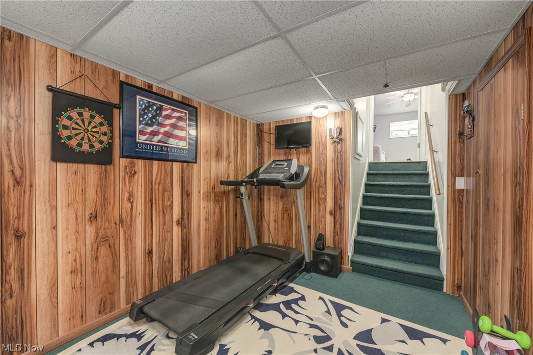 7094 Brandywine Road Parma Heights, OH 44130 - Photo 44 of 49 Workout room with a drop ceiling, wooden walls, and carpet