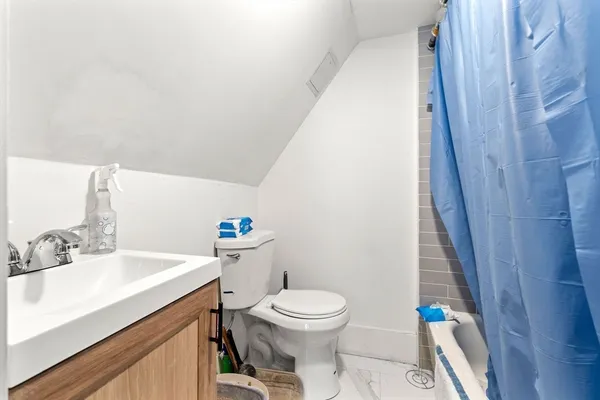 a bathroom with a sink a toilet and shower curtain