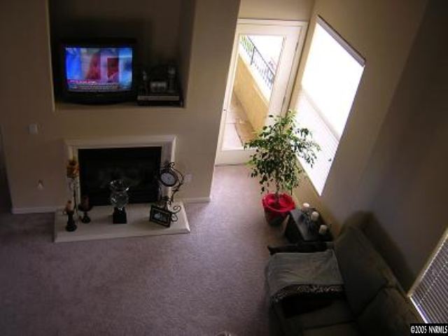 9050 Double R Bvld, Unit 1221 Reno, NV 89521 - Photo 6 of 8 a living room with furniture a fireplace and a flat screen tv