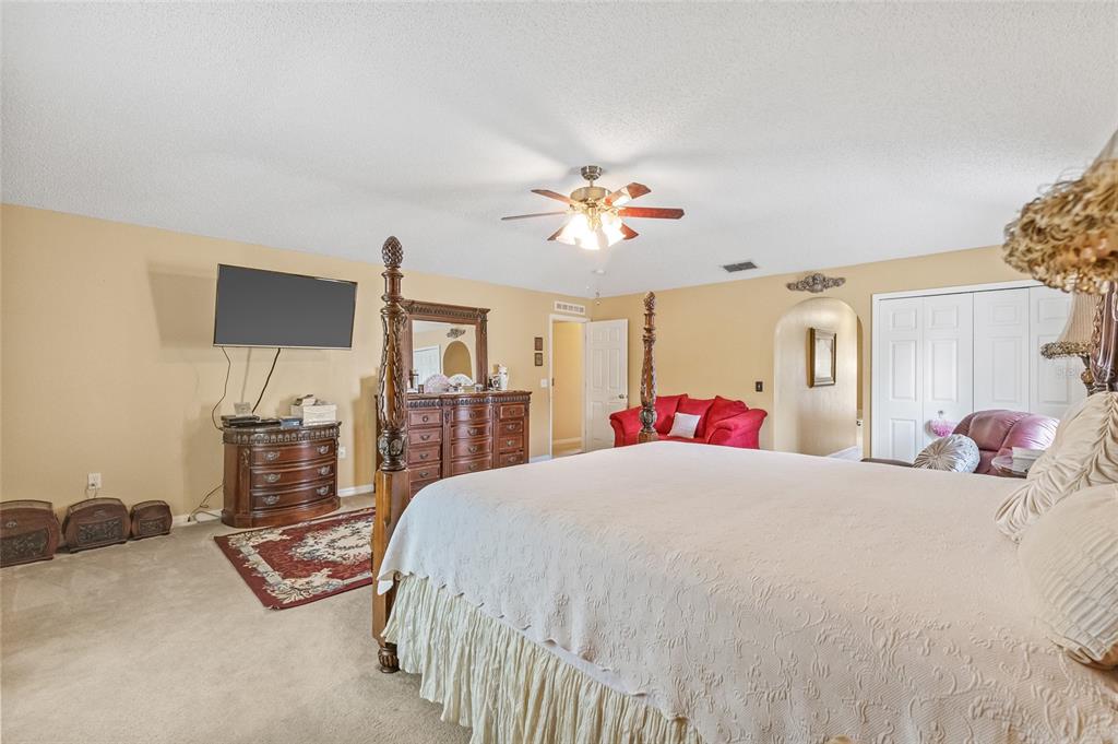 10311 Frog Pond Drive Riverview, FL 33569 - Photo 14 of 39 a bedroom with a bed dresser and a flat screen tv