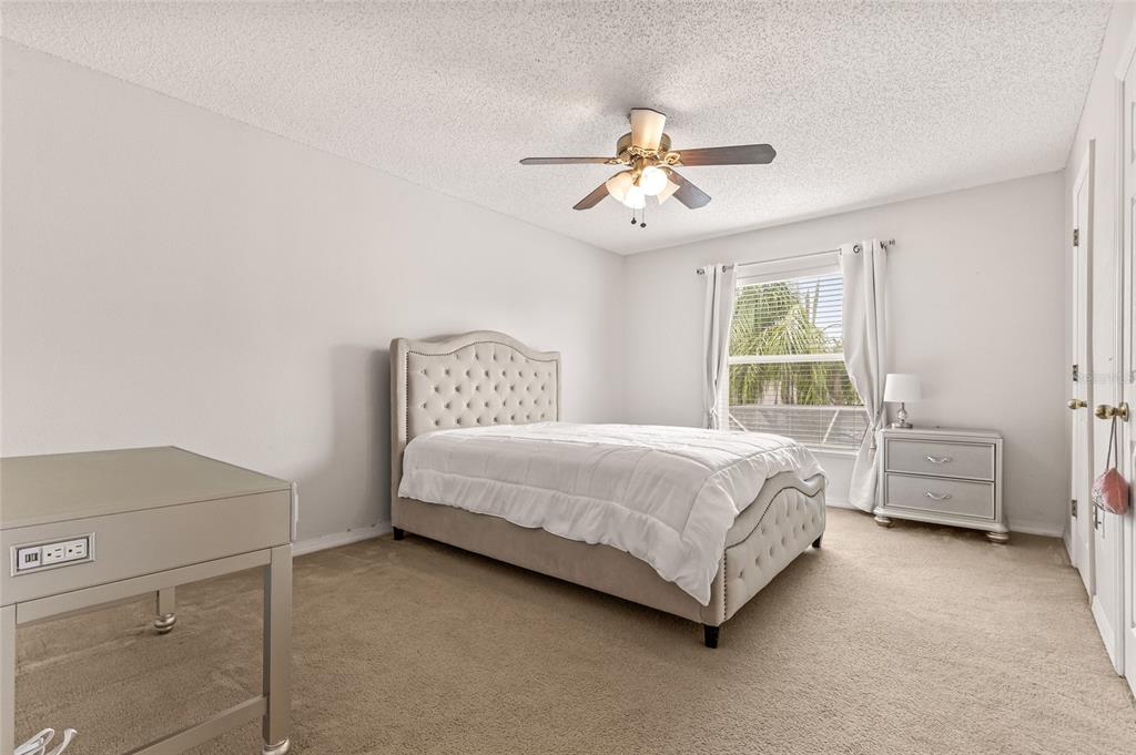 10311 Frog Pond Drive Riverview, FL 33569 - Photo 19 of 39 a bedroom with a bed and a chandelier