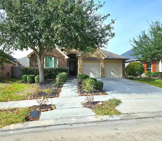 a front view of a house with a yard and potted plants