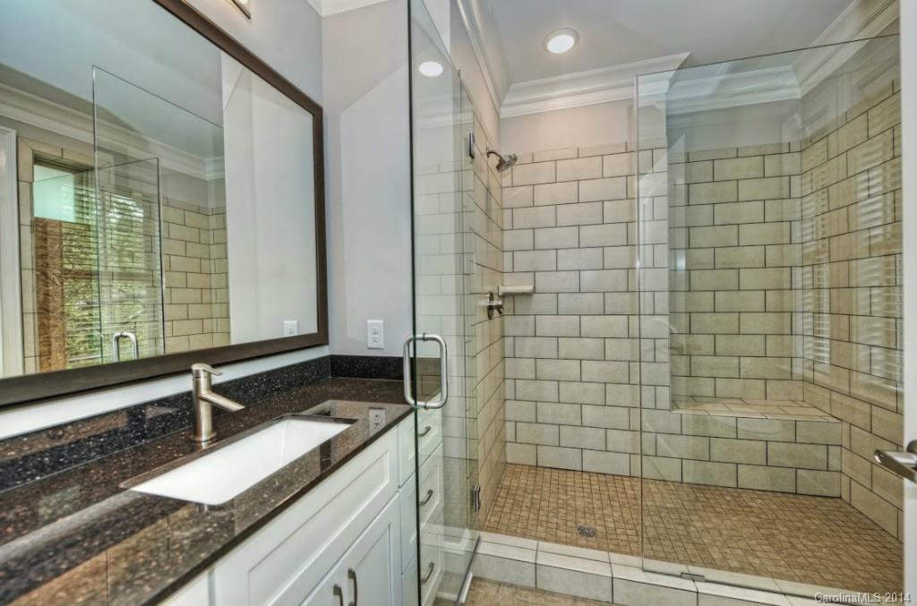2128 Queens Road West, Unit 2128 Charlotte, NC 28209 - Photo 16 of 21 a bathroom with a granite countertop sink a shower and a mirror