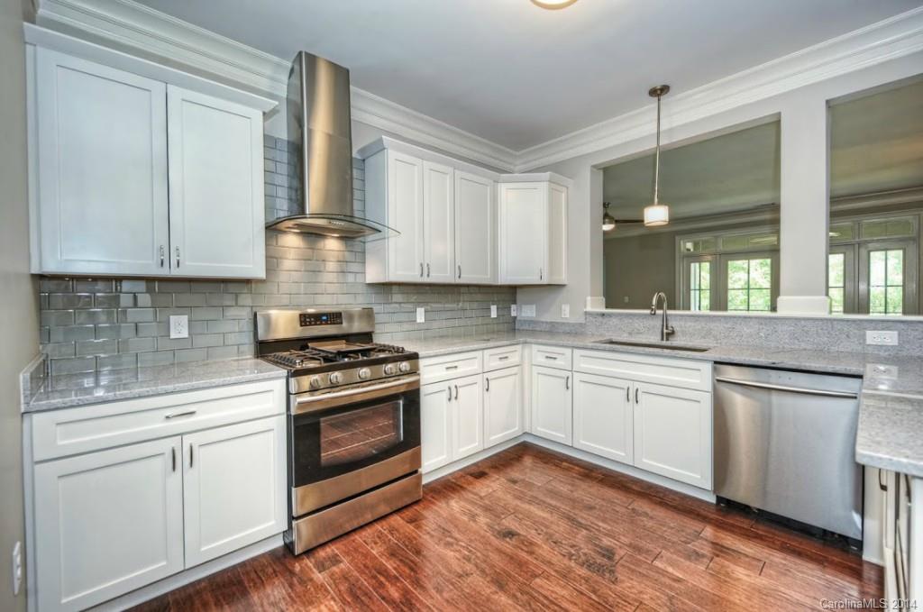 2128 Queens Road West, Unit 2128 Charlotte, NC 28209 - Photo 9 of 21 a kitchen with cabinets stainless steel appliances and wooden floor