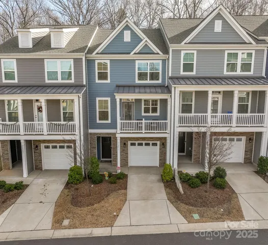 a front view of a house with a yard and potted plants