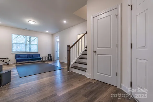 a view of a livingroom with wooden floor and stairs