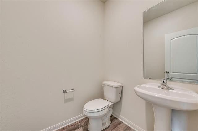 13609 Mineral Road Ponder, TX 76259 - Photo 18 of 21 Powder room featuring a pedestal sink with a chrome faucet, a rectangular wall mirror, and wood-finish flooring