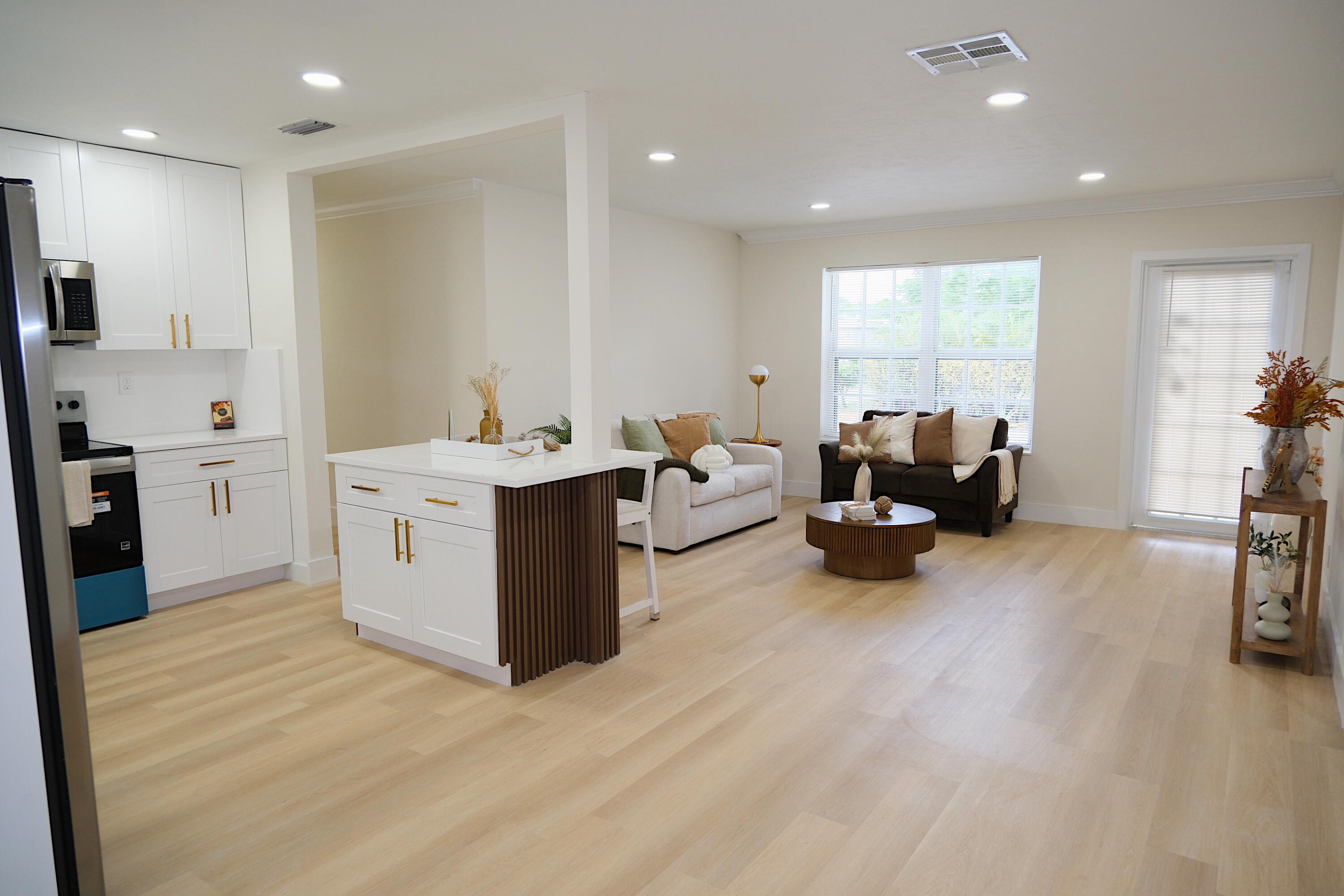 1084 Southwest 4th Avenue Pompano Beach, FL 33060 - Photo 9 of 35 a view of a kitchen with kitchen island a sink wooden floor and living room view