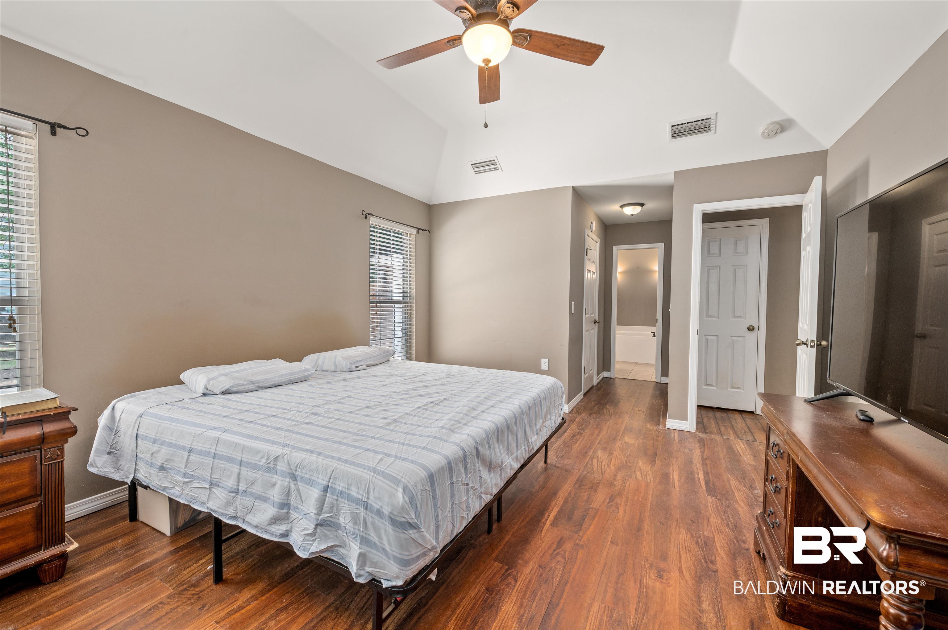 15240 Styx River Road Stapleton, AL 36578 - Photo 10 of 18 Bedroom featuring ceiling fan, vaulted ceiling, dark wood-type flooring, and multiple windows