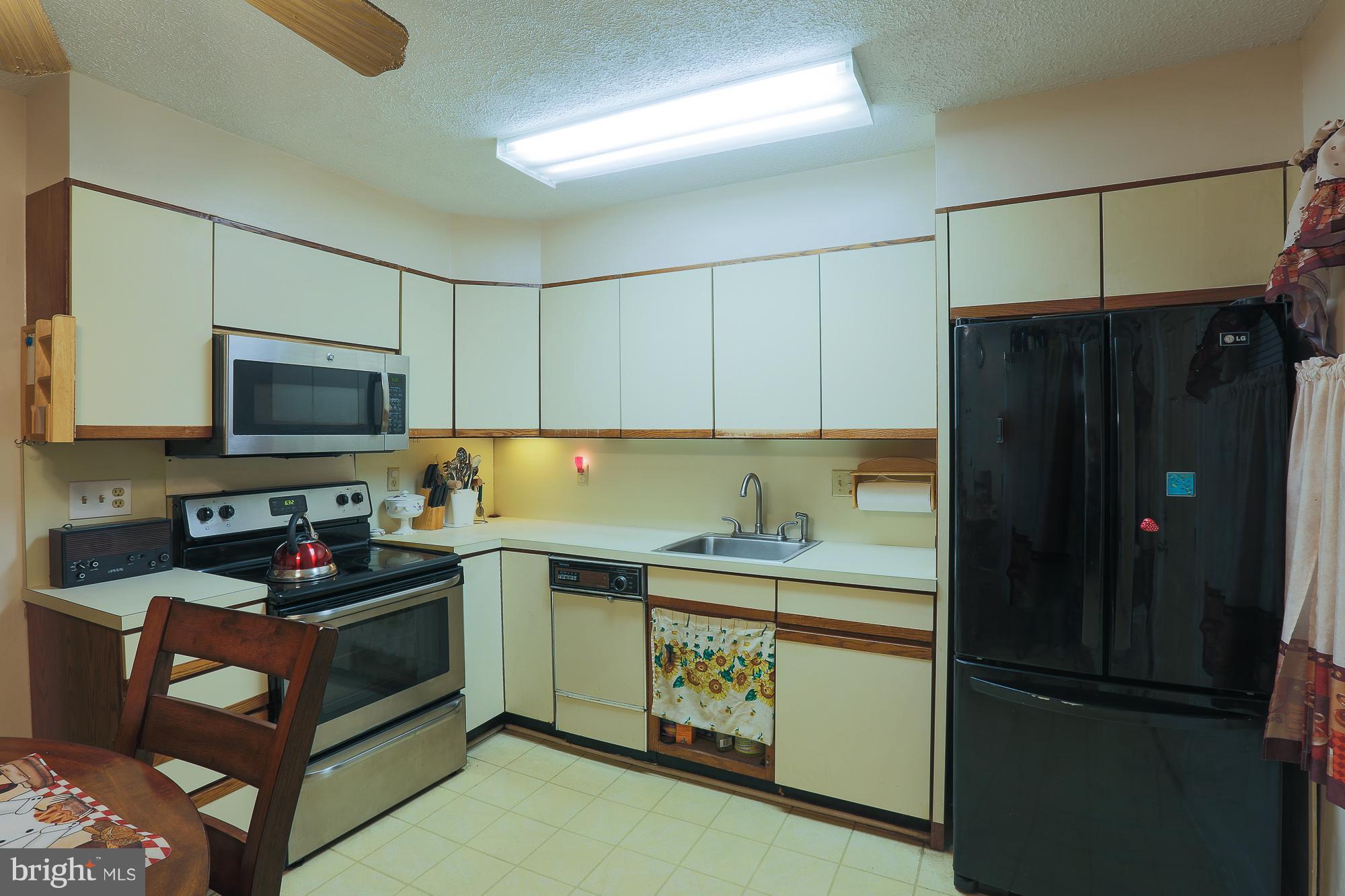 4119 Crest Heights Road Baltimore, MD 21215 - Photo 31 of 32 a kitchen with a refrigerator and a stove top oven