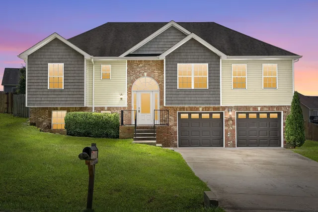 a front view of a house with a yard and garage