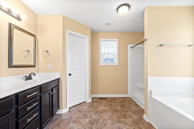 a bathroom with a tub sink and mirror