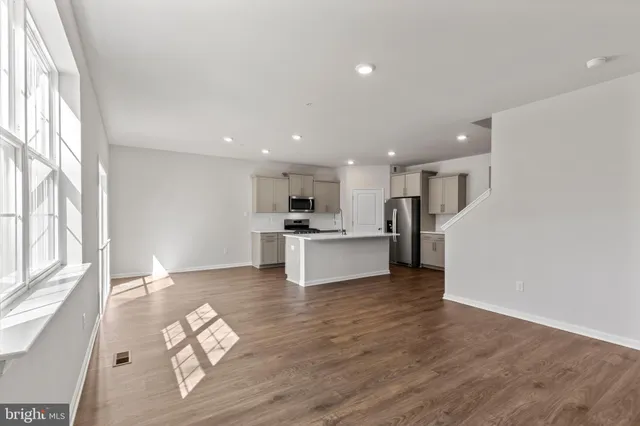 a view of kitchen dining table wooden floor and a large window