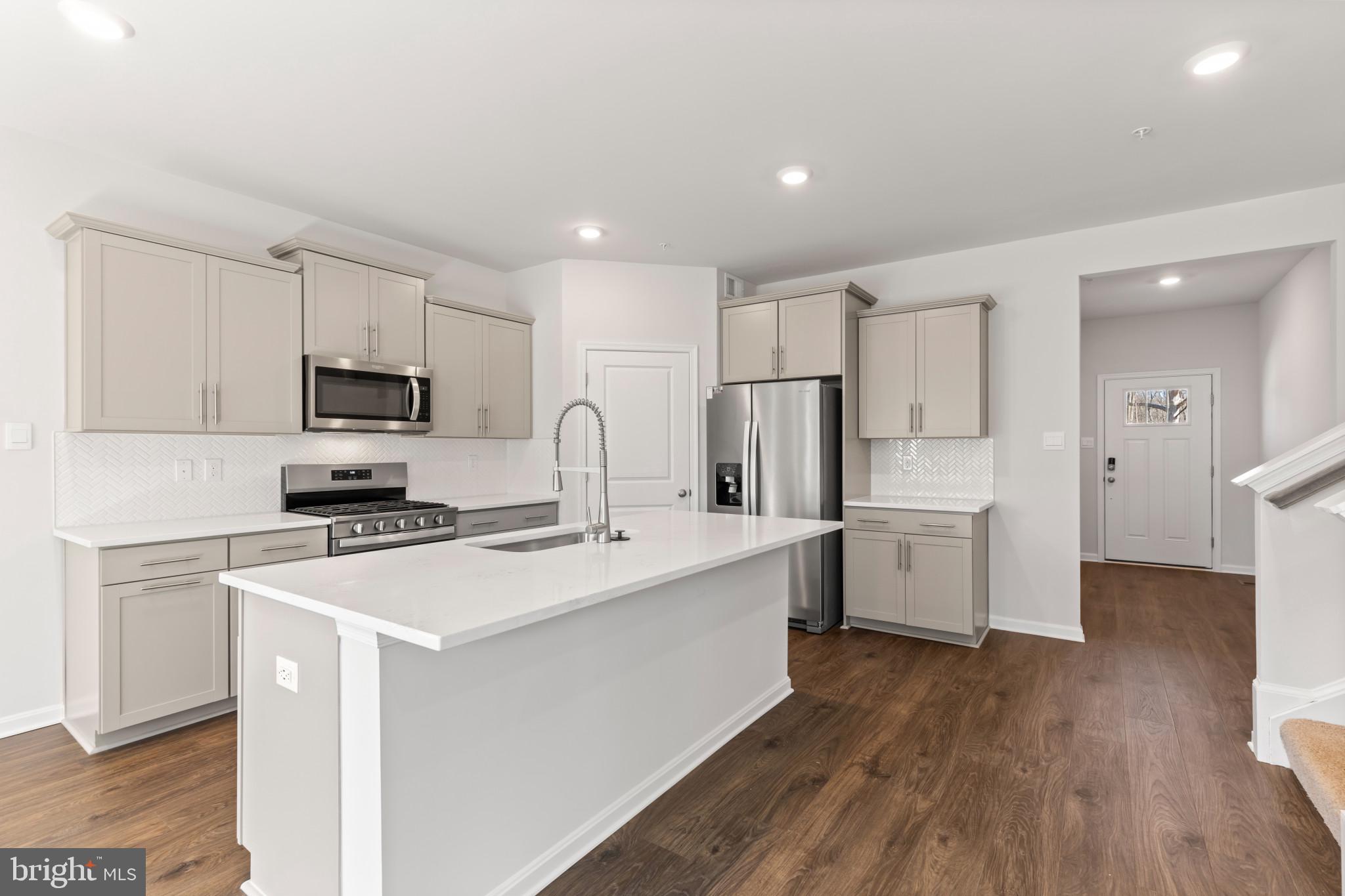 562 Atkinson Street Charles Town, WV 25414 - Photo 8 of 33 a kitchen with a sink a stove a refrigerator cabinets and a wooden floor