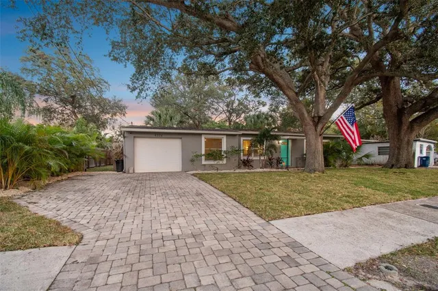 a front view of a house with a yard and trees