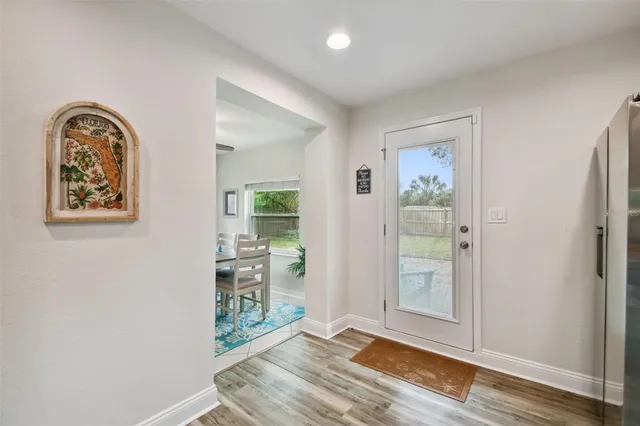 an empty room with wooden floor closet and windows