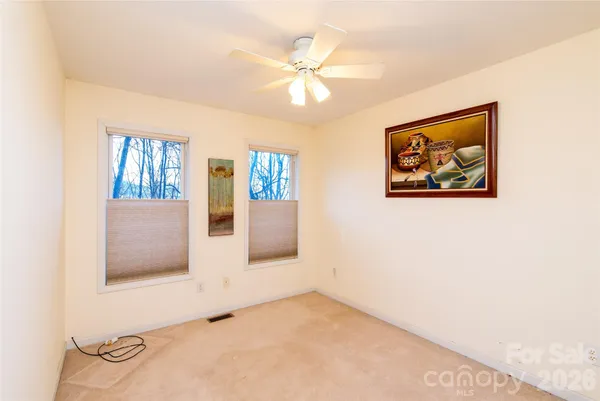 an empty room with windows and cabinet