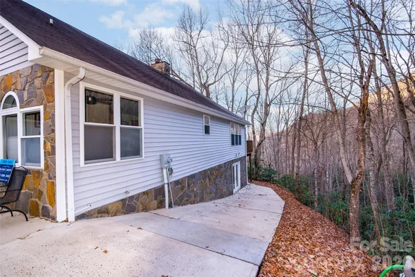 a view of backyard with large tree and wooden fence