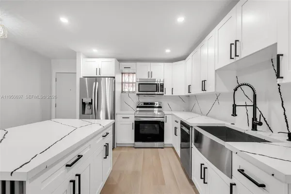 a kitchen with stainless steel appliances a sink stove and refrigerator