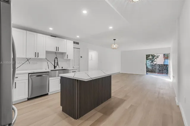 a kitchen with cabinets and wooden floor