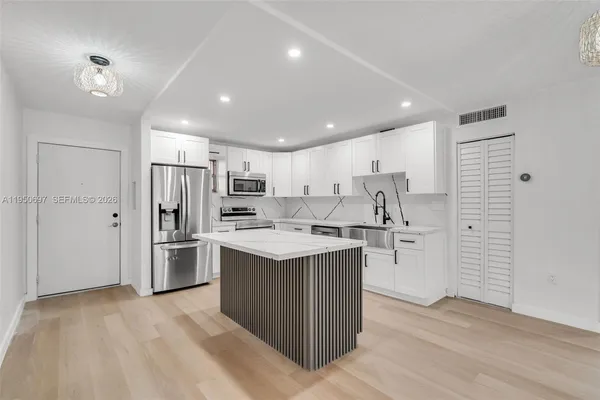 a kitchen with refrigerator and cabinets