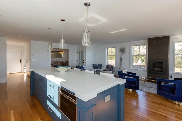 a large kitchen with kitchen island a stove a sink a center island and wooden floor