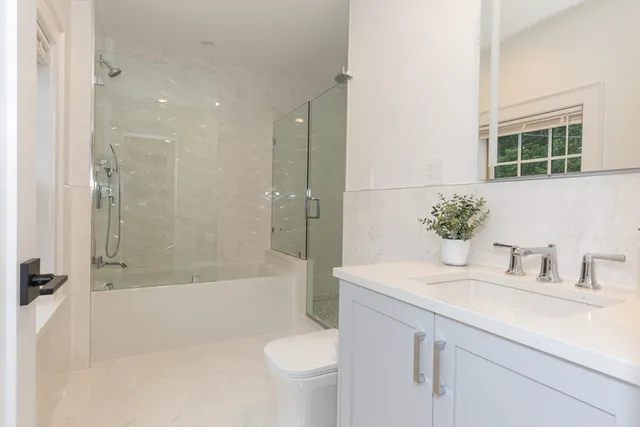 a bathroom with a sink a toilet and shower