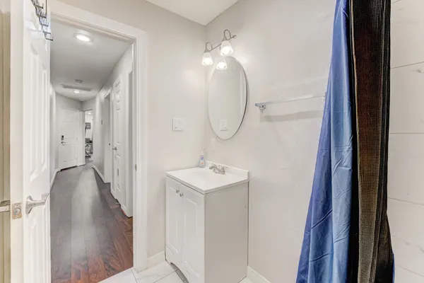 a bathroom with a sink a light fixture and a mirror