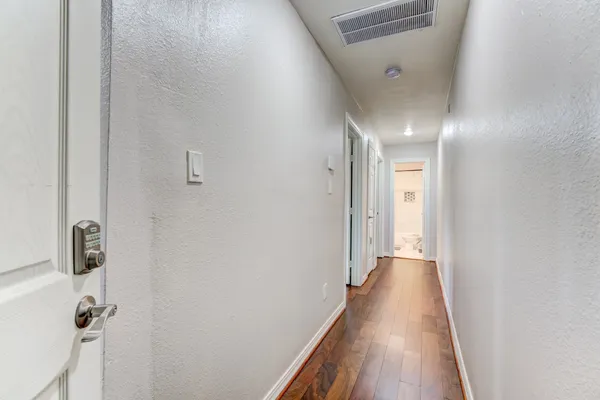 a view of a hallway with wooden floor