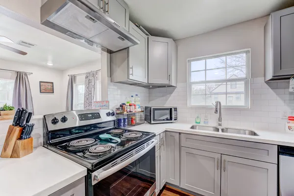 a kitchen with a stove a sink and a cabinets