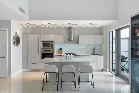 a kitchen with stainless steel appliances kitchen island granite countertop a refrigerator and a stove top oven