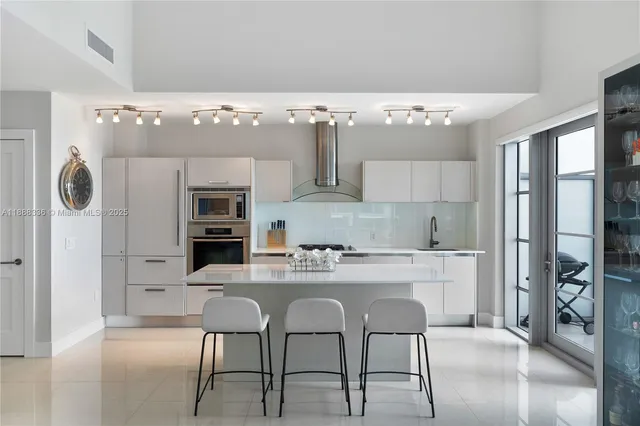 a kitchen with stainless steel appliances kitchen island granite countertop a refrigerator and a stove top oven