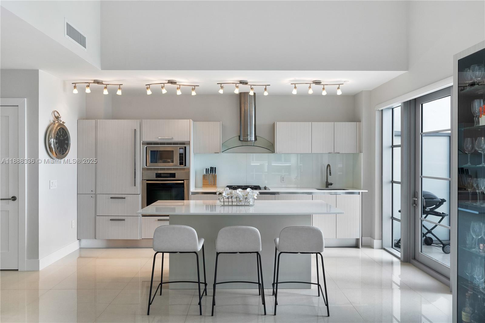 3739 Collins Avenue, Unit N605 Miami Beach, FL 33140 - Photo 4 of 20 a kitchen with stainless steel appliances kitchen island granite countertop a refrigerator and a stove top oven