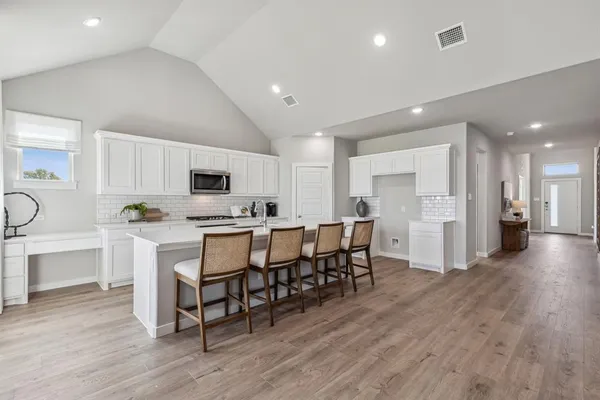 a kitchen with white cabinets and stainless steel appliances