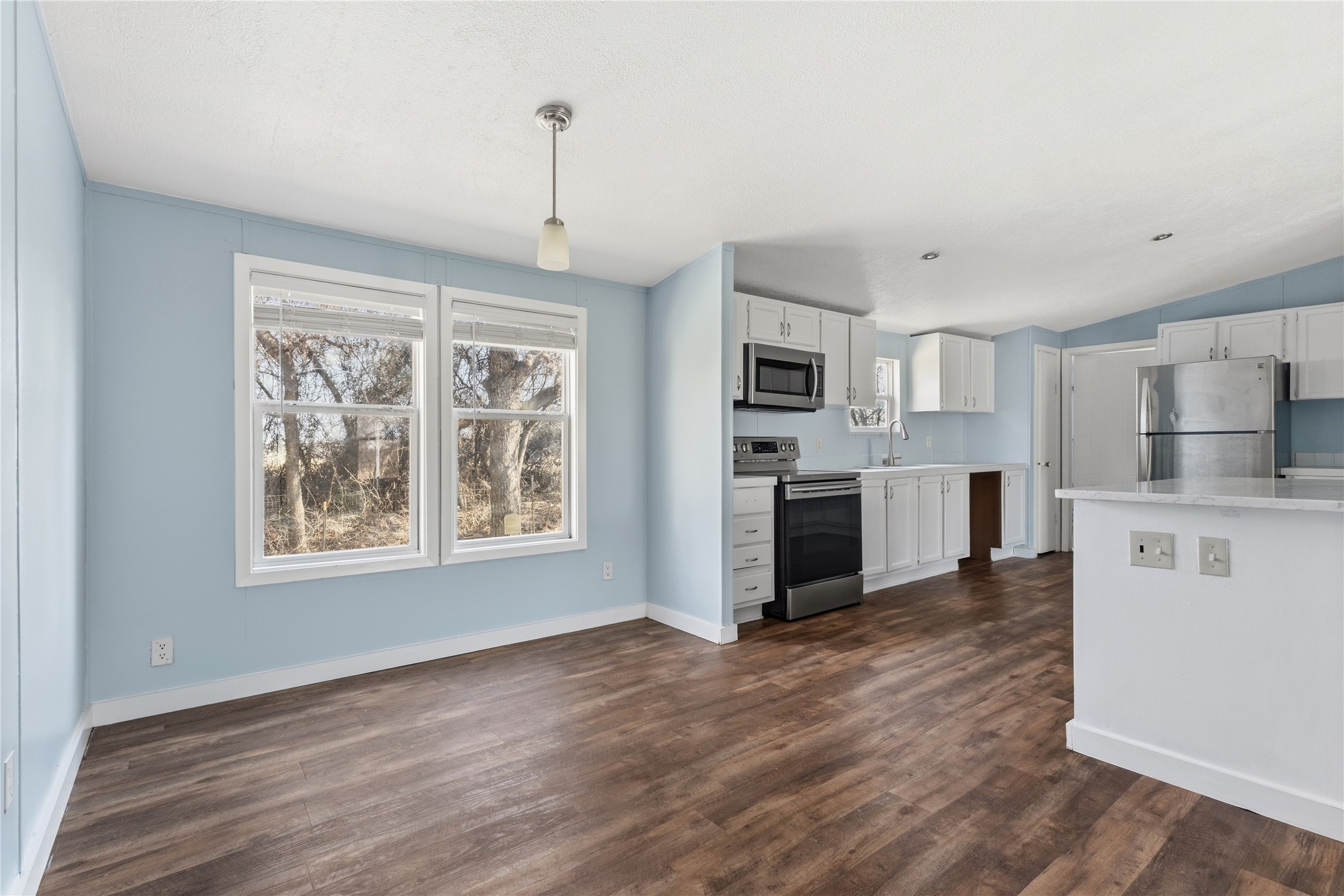 1029 Old McDade Road, Unit C Elgin, TX 78621 - Photo 12 of 33 a open kitchen with white cabinets and wooden floor