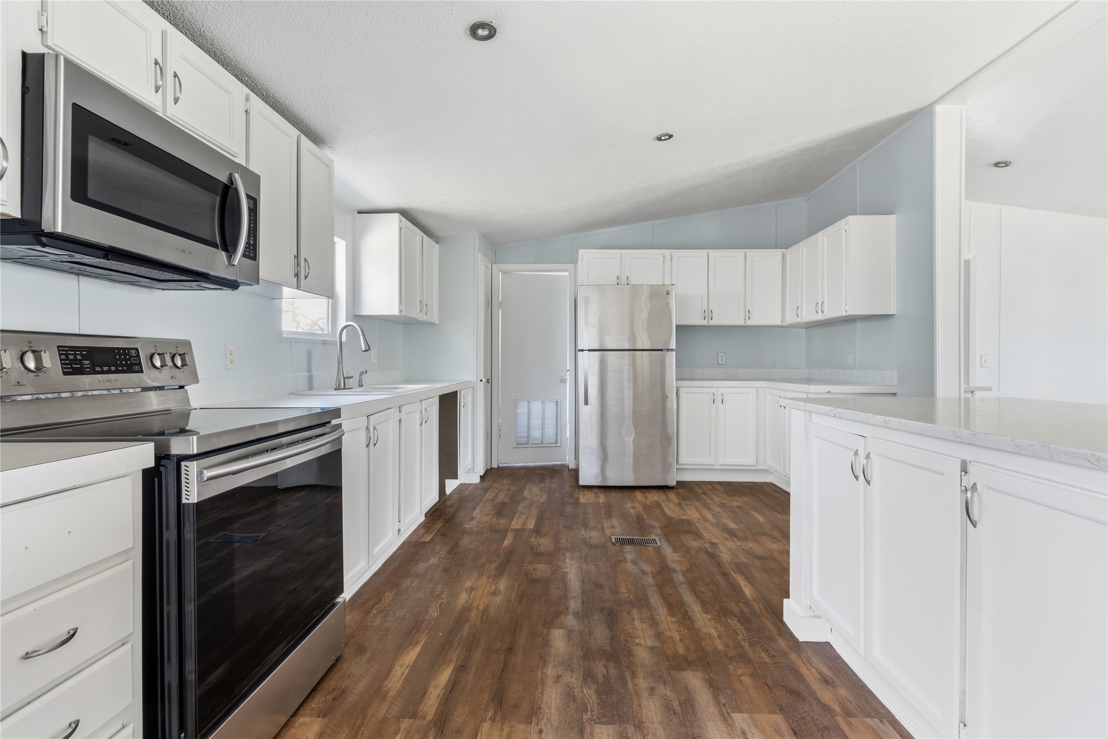 1029 Old McDade Road, Unit C Elgin, TX 78621 - Photo 14 of 33 a kitchen with granite countertop a refrigerator a stove top oven a sink dishwasher and wooden cabinets