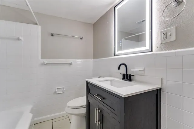 a bathroom with a sink vanity and a toilet