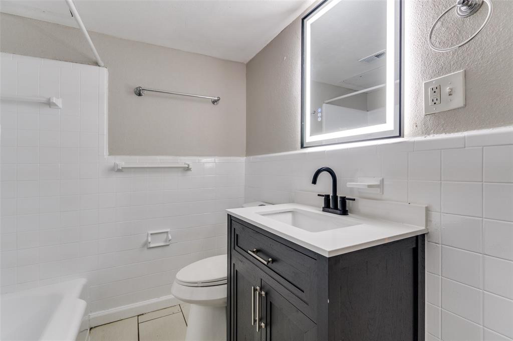 4618 Reiger Avenue, Unit 101 Dallas, TX 75246 - Photo 12 of 17 a bathroom with a sink vanity and a toilet