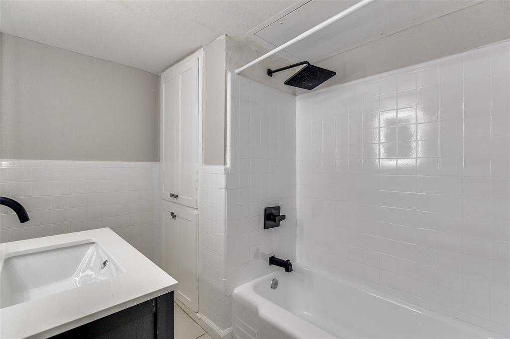 4618 Reiger Avenue, Unit 101 Dallas, TX 75246 - Photo 13 of 17 a bathroom with a sink and a bathtub