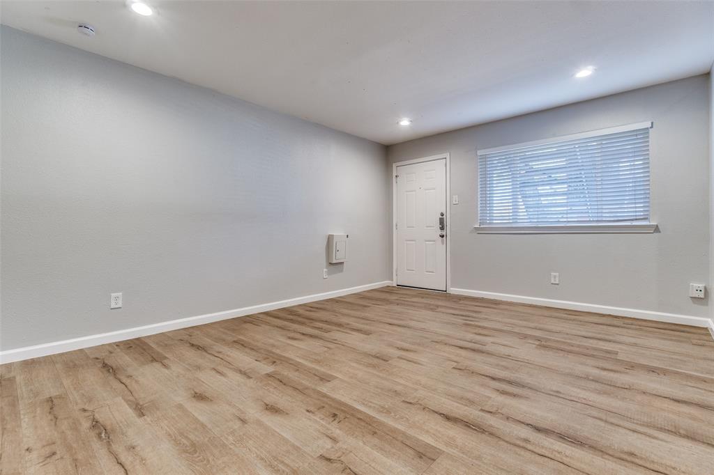 4618 Reiger Avenue, Unit 101 Dallas, TX 75246 - Photo 4 of 17 an empty room with wooden floor and windows