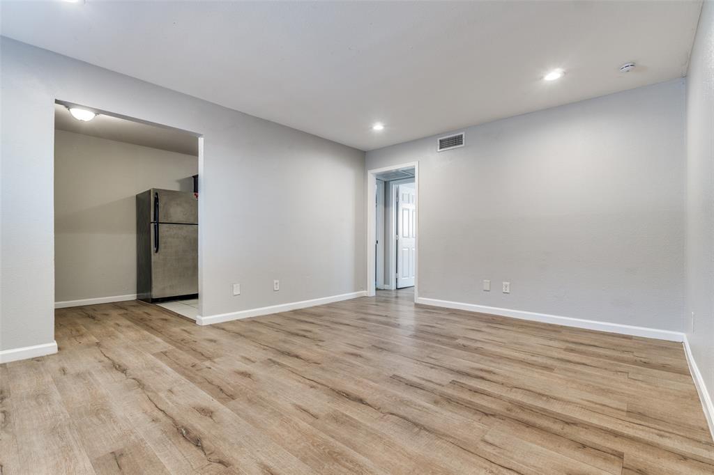 4618 Reiger Avenue, Unit 101 Dallas, TX 75246 - Photo 6 of 17 an empty room with wooden floor and windows
