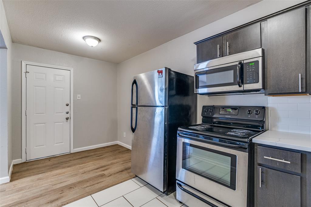 4618 Reiger Avenue, Unit 101 Dallas, TX 75246 - Photo 8 of 17 a kitchen with granite countertop cabinets and steel stainless steel appliances