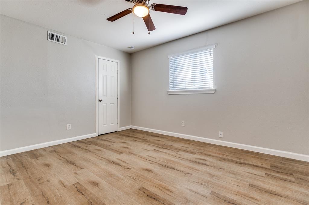 4618 Reiger Avenue, Unit 101 Dallas, TX 75246 - Photo 10 of 17 an empty room with wooden floor ceiling fan and windows