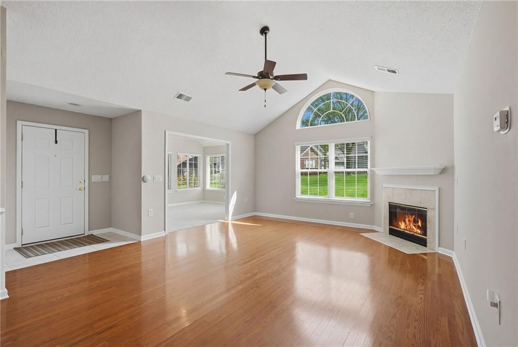 2994 Oakside Circle Alpharetta, GA 30004 - Photo 12 of 32 an empty room with windows fireplace and wooden floor