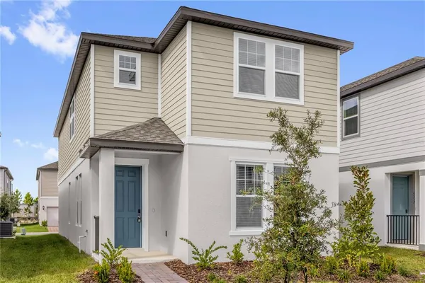 a view of a house with a yard and potted plants