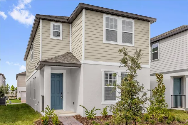 a view of a house with a yard and potted plants